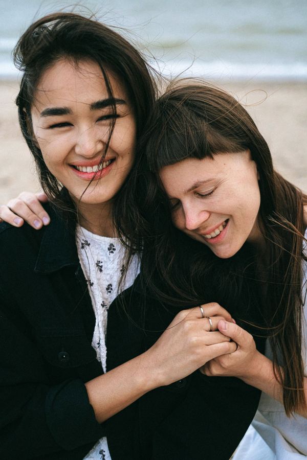 Two women laughing together on a beach