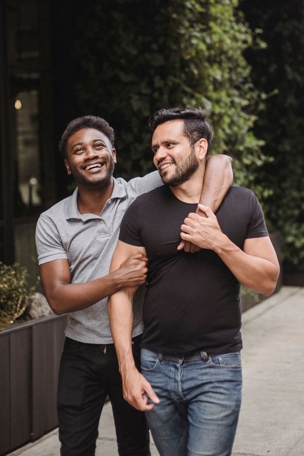 Two men walking with their arms around each other